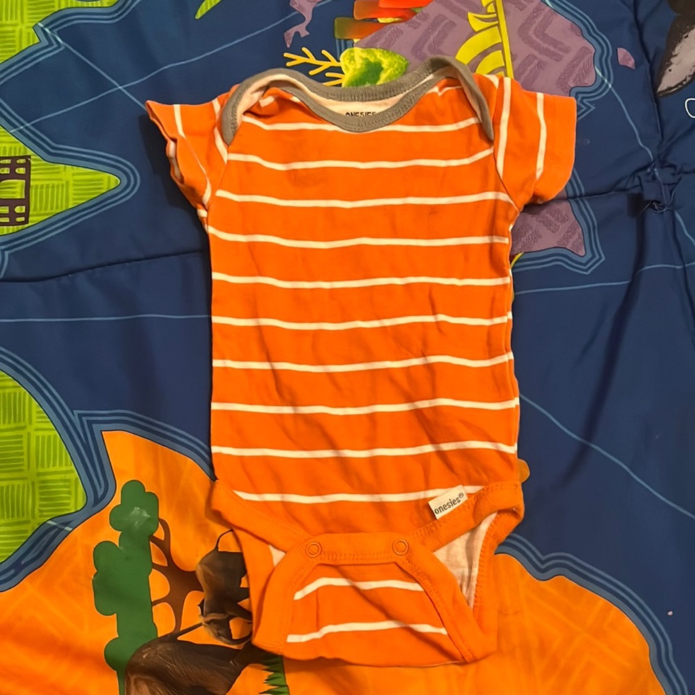 Orange onesie white strips and gray around the collar